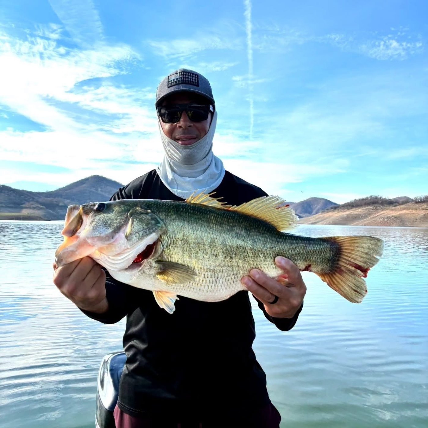 Pescador con lobina en embarcación
